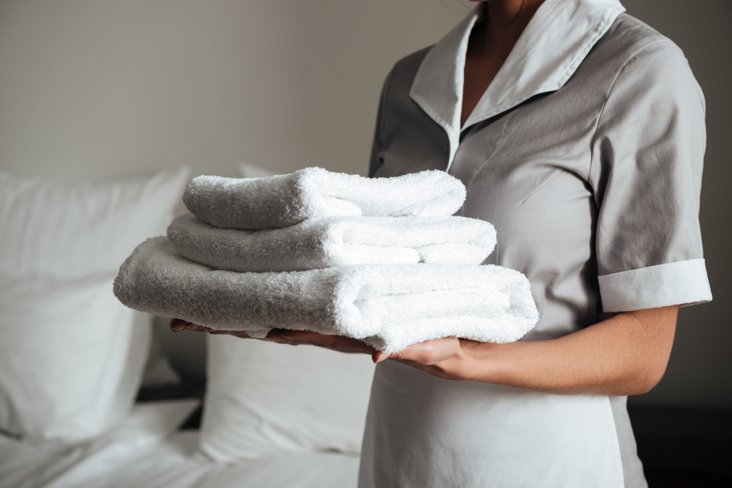 young maid holding folded towels